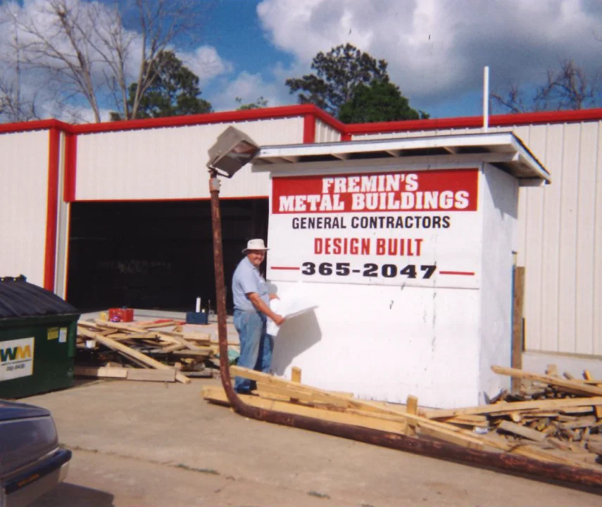 Fremin founder standing in front of company logo